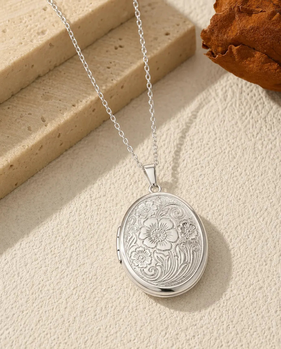 Oval photo locket necklace in polished silver with vintage wildflower engraving