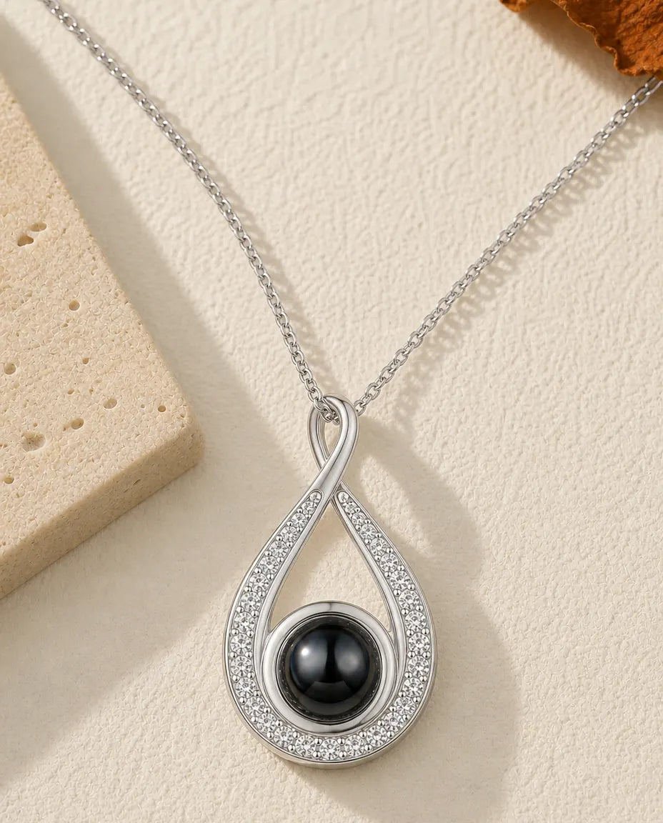 Teardrop photo projection necklace in silver with pave crystal arms and a black bead